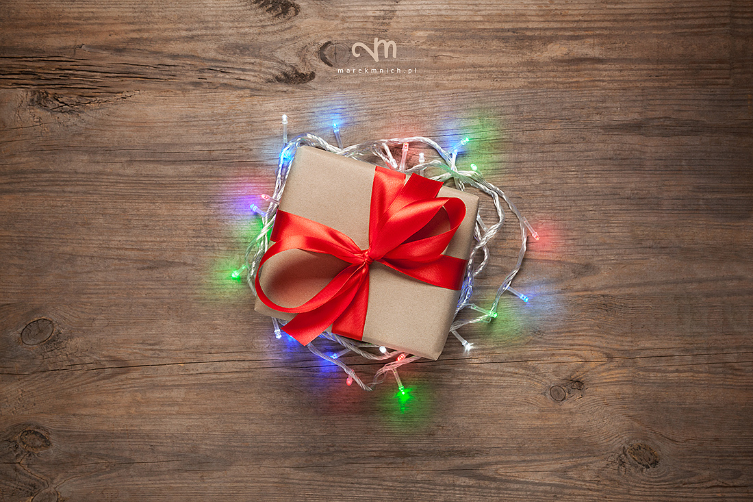 Gift box with christmas lights on wooden table