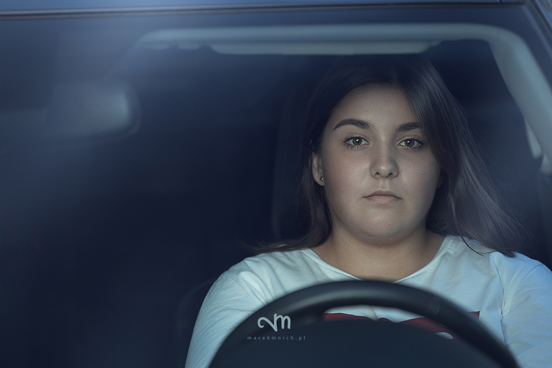 Portrait of girl driving car by night
