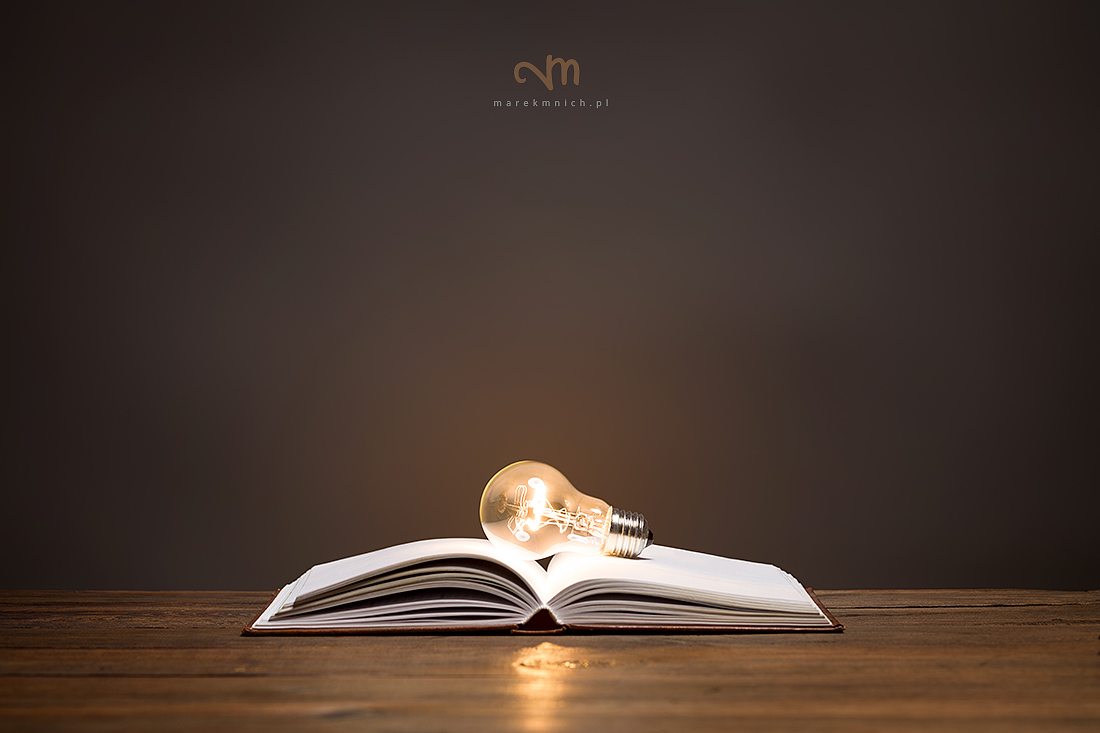 Incandescent bulb on open book