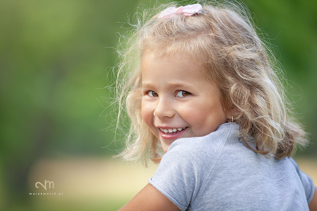 Smiling cute little girl on green background
